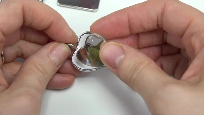 Apply glue to the back of the glass gem and place it on top of the image, pressing gently to secure.