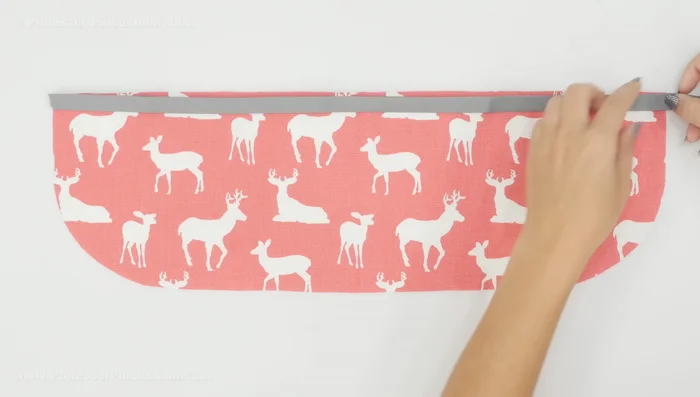 Attach bias tape to pocket: Cut a bias tape strip for the pocket's top edge. Open the bias tape, pin it to the wrong side of the pocket, aligning raw edges, and stitch along the crease. Fold the bias tape over and stitch again along the folded edge to create a finished look.