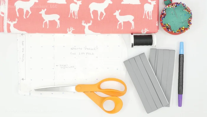 Cut fabric pieces: Cut one main apron piece and one pocket piece, both on the fold, using downloaded pattern pieces. Ensure directional fabric is placed correctly.