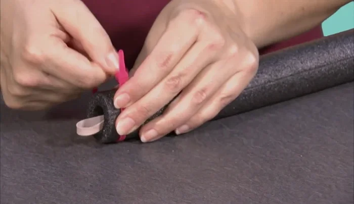 Attach a second zip tie tightly around the nose of the rocket, ensuring the string is pulled down significantly so the rubber band barely protrudes.