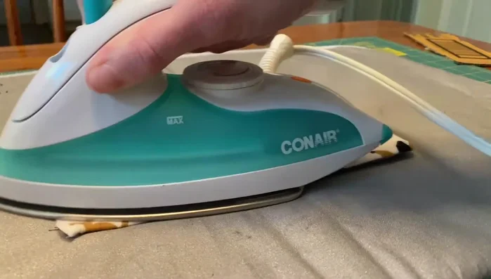 Insert cardboard: Place the cardboard rectangle inside the fabric sleeve.