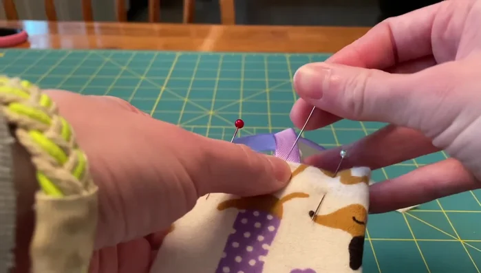 Insert ribbons and sew: Insert ribbons into the top seam, pin, and sew along the top edge to close and secure the ribbons simultaneously. Make sure you’re only sewing through the fabric and not the cardboard.