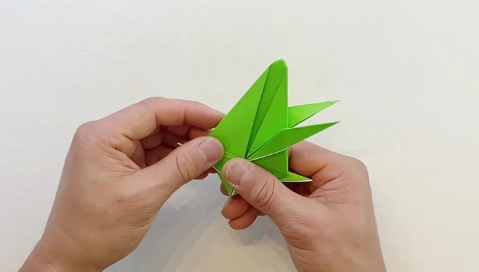 Bring one side slightly downward, open from the bottom and fold it down. Repeat on the other side.