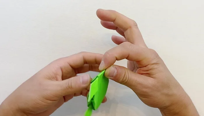 Fold the head backward, then upward. For a rounder head (optional), fold along a line and fold downward.