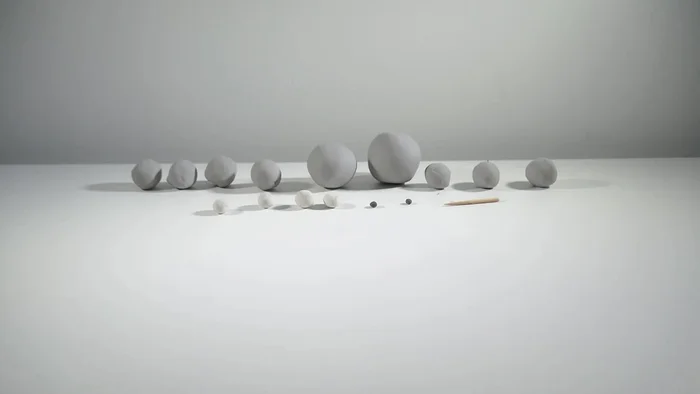 Prepare clay balls of different sizes in gray, black, and white.