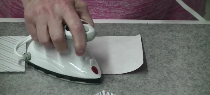 Iron a contrasting charm square onto the glued side of the first square.