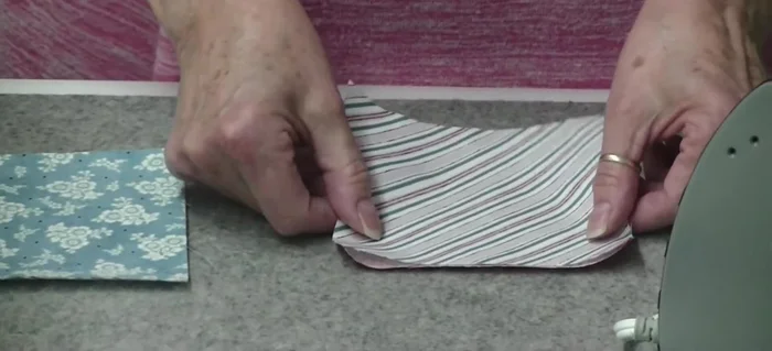 Iron a contrasting charm square onto the glued side of the first square.