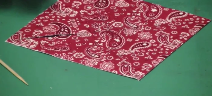 Use a skewer to press and adhere the fabric points to the center, creating the pinwheel shape. 