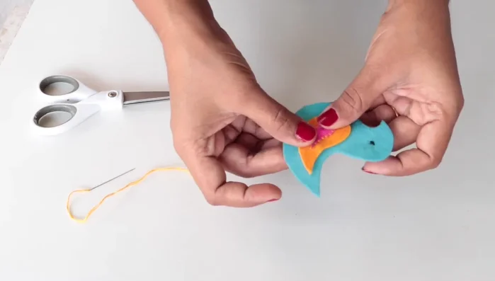 Stitch the feather pieces onto the bird body.