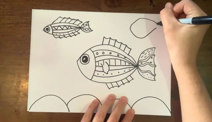 Draw a third fish: a different shape, adding variety to the scene.