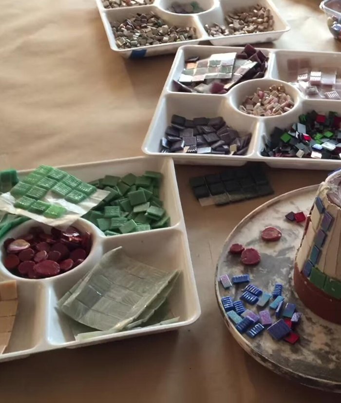 Apply mosaic materials to the adhesive.