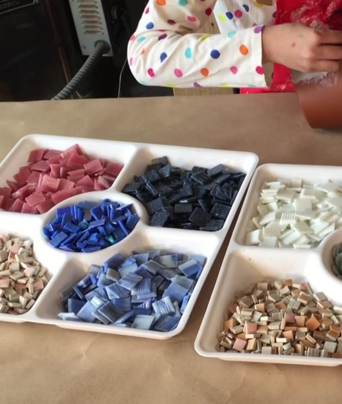 Apply mosaic materials to the adhesive.