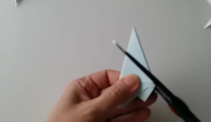 Cut along the center of the folded shape from the starting point to the middle of the base.