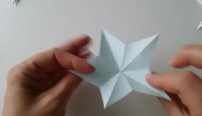 Open the star, adjusting the folds to point upwards.
