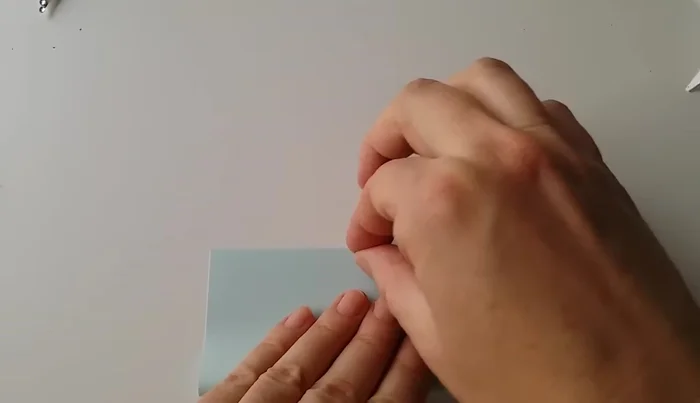 Fold the square paper in half.
