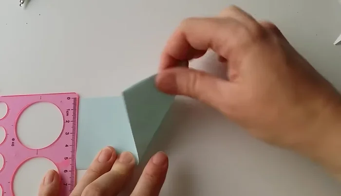 Fold one corner to the left side, aligning it with a point approximately 1/3 from the top and 2/3 from the bottom.