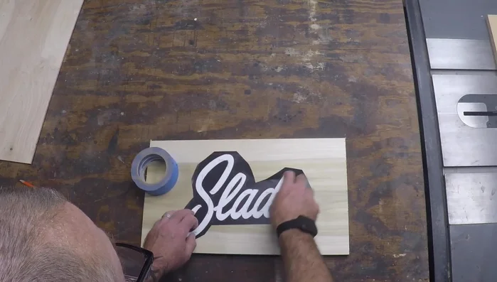 Cover the wood with blue painter's tape to facilitate stencil removal and prevent glue residue.