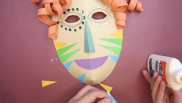 Add more colored paper strips to personalize your mask.