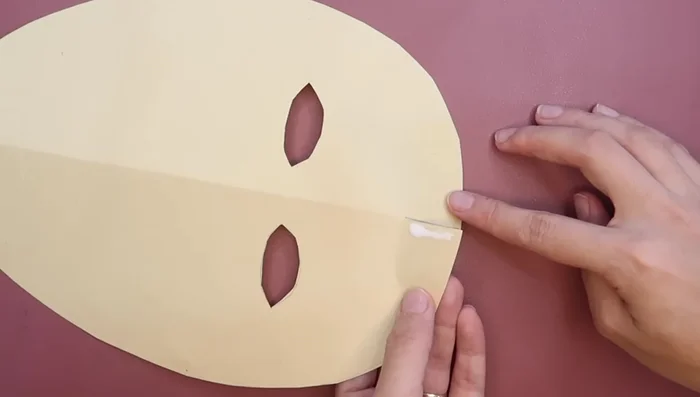 Apply glue to one side of the tabs and overlap them to create a 3D effect for the mask.