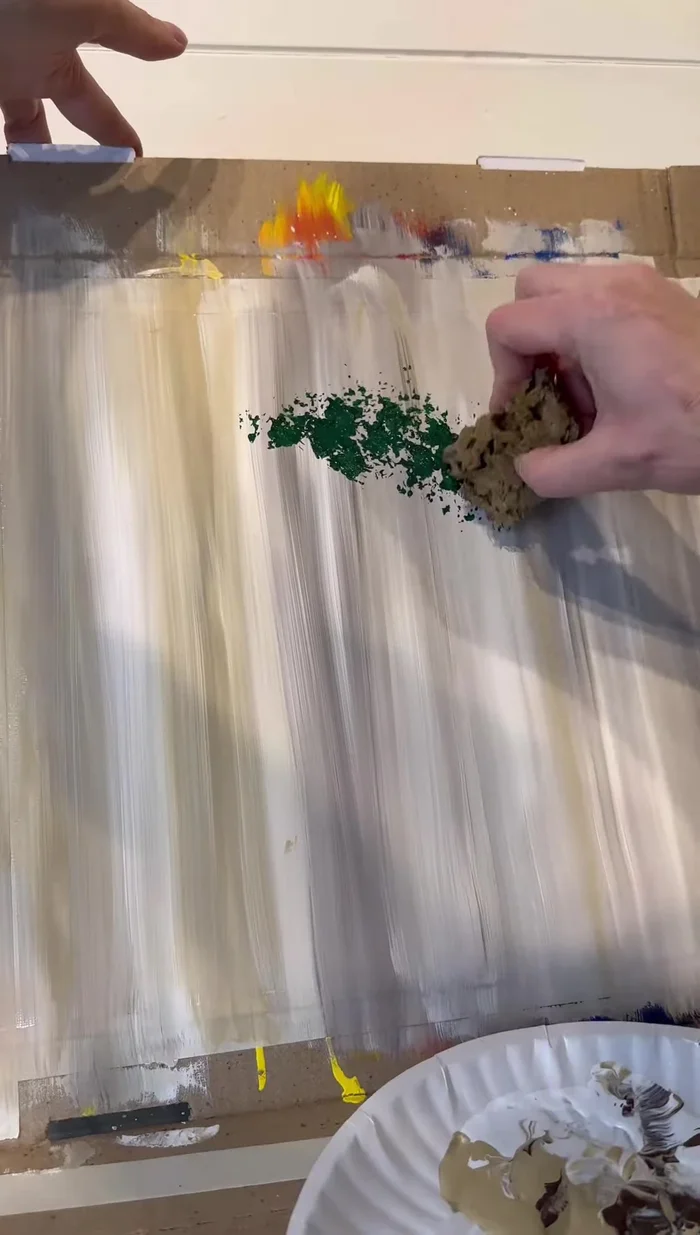 Dry the base. Then, use a sea sponge with Christmas green and darker green paints to create the wreath shape by bouncing the sponge in a circular motion.