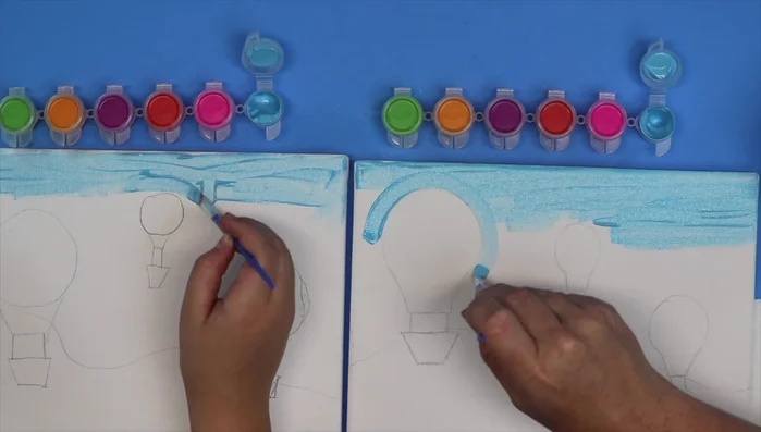 Paint the hot air balloon baskets orange, using small dots or short strokes for texture.