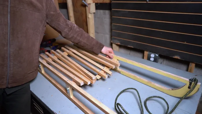 Repair broken sled: Remove broken pieces, replace with sturdier wood, and add a third support for weight distribution. Attach new brackets and slats.