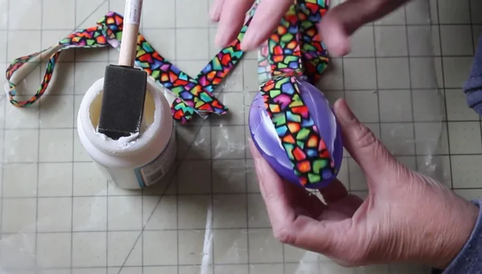 Place a fabric strip over the Mod Podge, starting at the bottom and working your way up. Smooth out any puckers or wrinkles with your fingers.