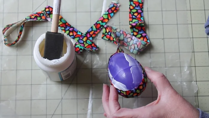 Continue adding fabric strips, overlapping slightly, until the entire egg is covered. Smooth out any wrinkles as you go.