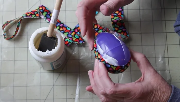 Continue adding fabric strips, overlapping slightly, until the entire egg is covered. Smooth out any wrinkles as you go.