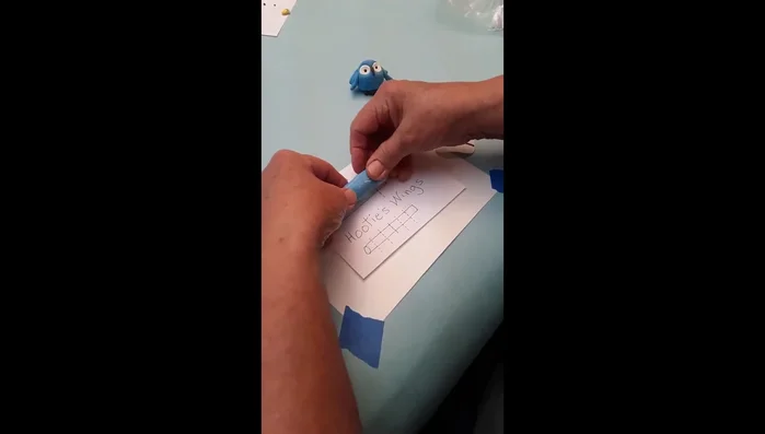 Assemble Hoodie (Blue Owl): Roll blue clay onto the pattern, cut, and shape wing pieces. Form body and head. Make eye sockets, add white and black eye details, attach beak. Use straw tool to create feather markings. Attach feet and wings.