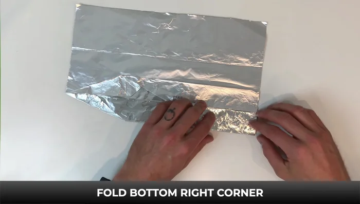 Fold down the right side to the bottom, flip it over, and fold down. Flip again and fold down. Turn it over; fold down the top left corner and edge to the line.