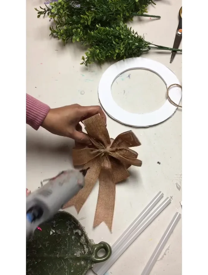 Glue the burlap bow and greenery (boxwood) to the wreath.