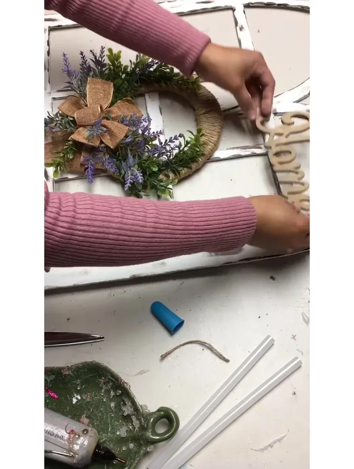 Attach the wreath and wooden sign (optional) to the window frame.