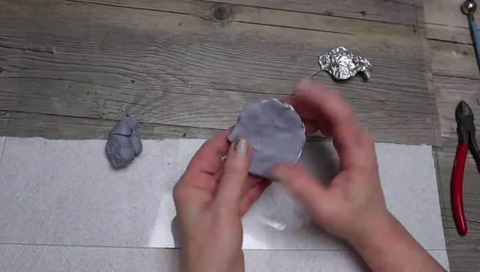 Make a worm: Add clay to floral wire, create a slightly larger head, add rings, and bend into shape.