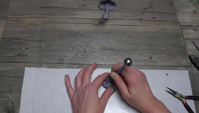 Make a worm: Add clay to floral wire, create a slightly larger head, add rings, and bend into shape.