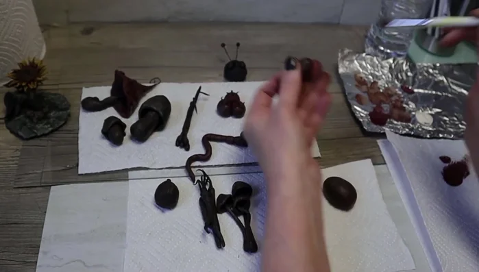 Bake the clay pieces. Once cooled, paint with a dark base coat (black and brown mix). Add layers of color from dark to light, dabbing the paint on.