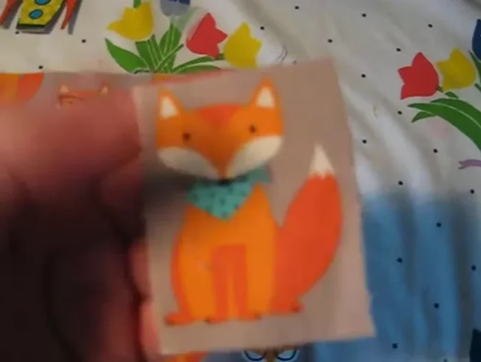 Place another piece of felt (preferably the same color as the edges of the image, or a contrasting color for a unique look) on top, aligning it with the first piece of felt and the fabric image.