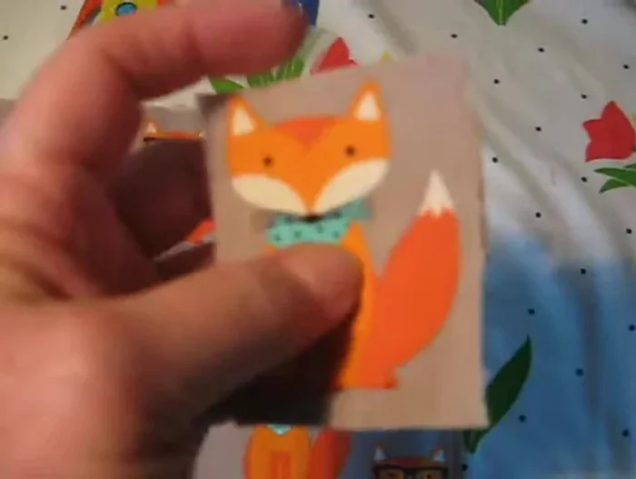 Place another piece of felt (preferably the same color as the edges of the image, or a contrasting color for a unique look) on top, aligning it with the first piece of felt and the fabric image.