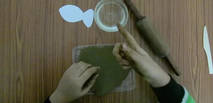 Knead clay with water, flatten, and smooth with a rolling pin.