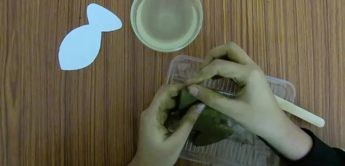 Smooth the edges of the clay fish using water and your fingers or a brush.