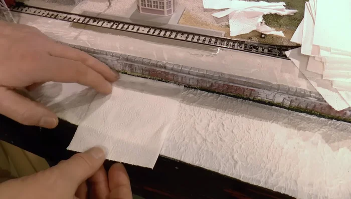 Apply the third layer of toilet paper: Soak thoroughly and smooth out any patterns or lines with the brush.