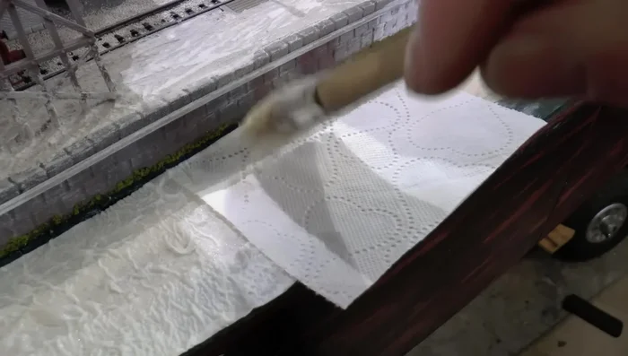 Apply the third layer of toilet paper: Soak thoroughly and smooth out any patterns or lines with the brush.