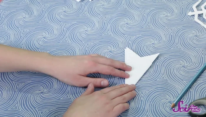 Use a pencil to lightly draw the desired design onto the folded paper, ensuring you leave the central fold intact. Be creative and experiment with patterns!