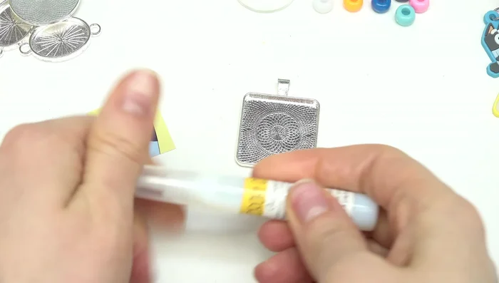 Place the cabochon glass piece over the image, pressing gently to ensure adhesion and remove excess glue with a towel.