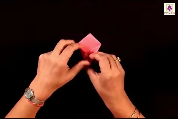 Unfold and open the flap. Bring the top side to the center line, pressing the sides simultaneously. Repeat on all four sides.