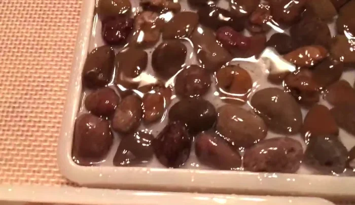 Use the flame torch again to remove any remaining bubbles after adding pebbles.