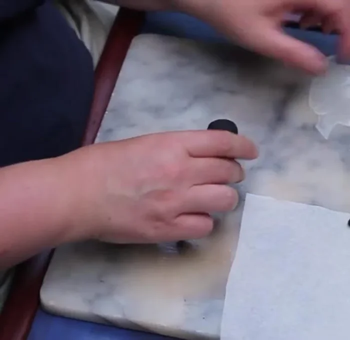 Roll the larger part (2/3) into a ball to form the spider's body.