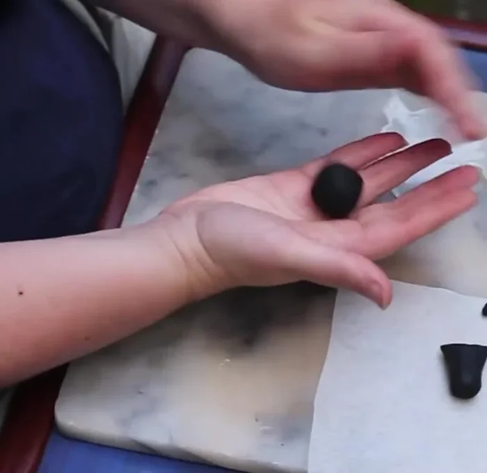 Roll the larger part (2/3) into a ball to form the spider's body.