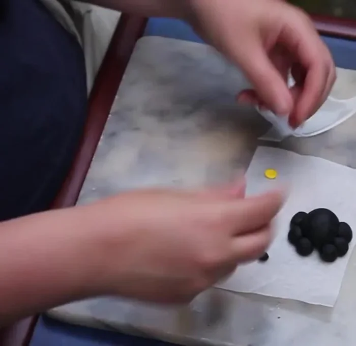 Roll out a thin sausage of black clay and cut two small pieces for the pupils. Attach to the eyes.