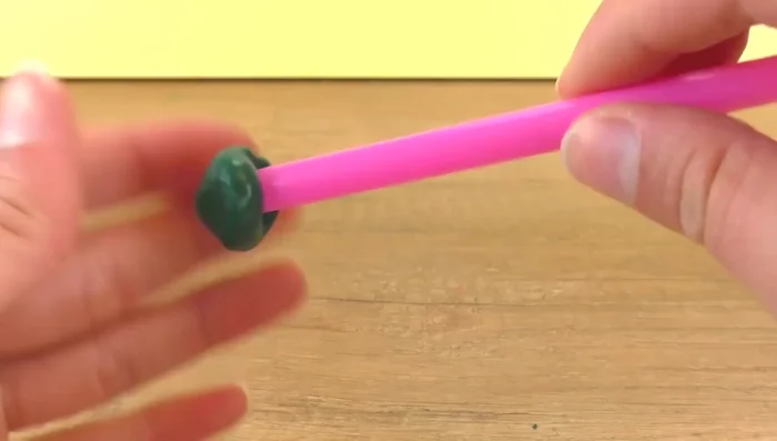 Blow gently through the straw to inflate the material.